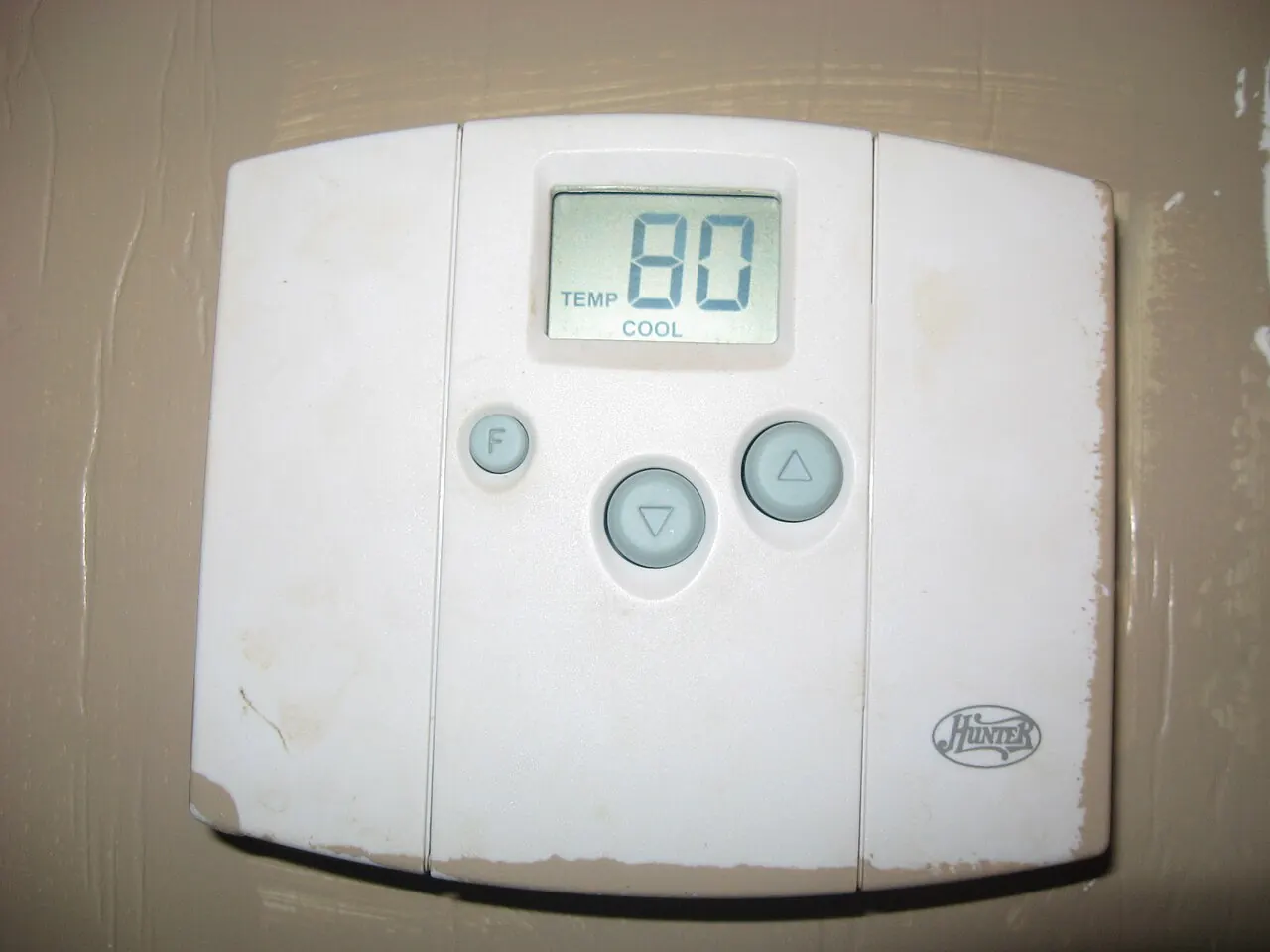 Digital wall thermostat showing 80 degrees in cool mode
