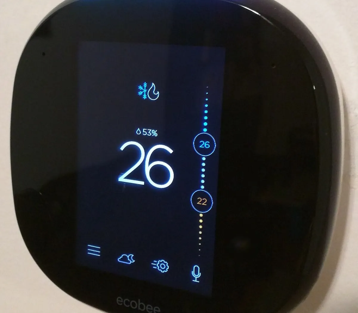 ecobee smart thermostat on a wall showing 26 degrees, 53 percent humidity and heat and cool set points