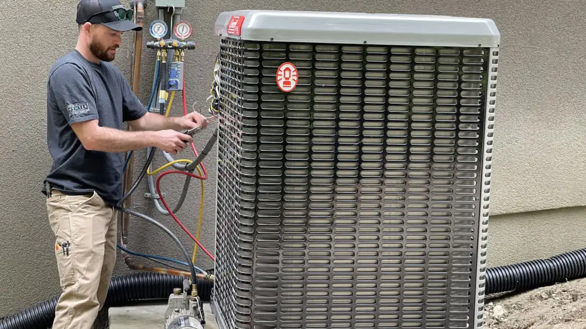 Installer standing next to a new outdoor heat pump unit