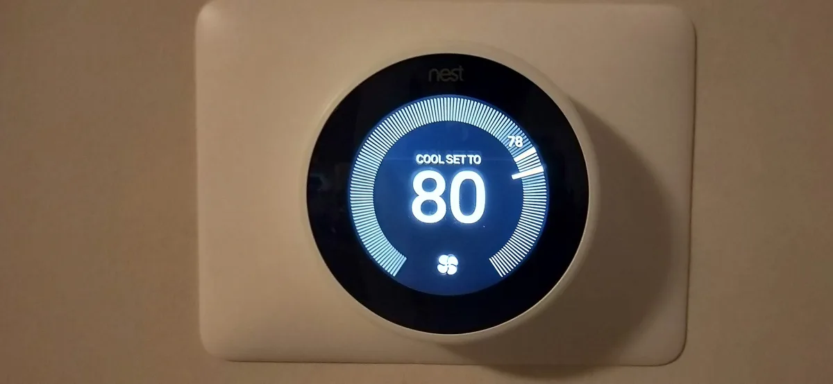 Nest Learning Thermostat on a living room wall, set to cool at 80 degrees